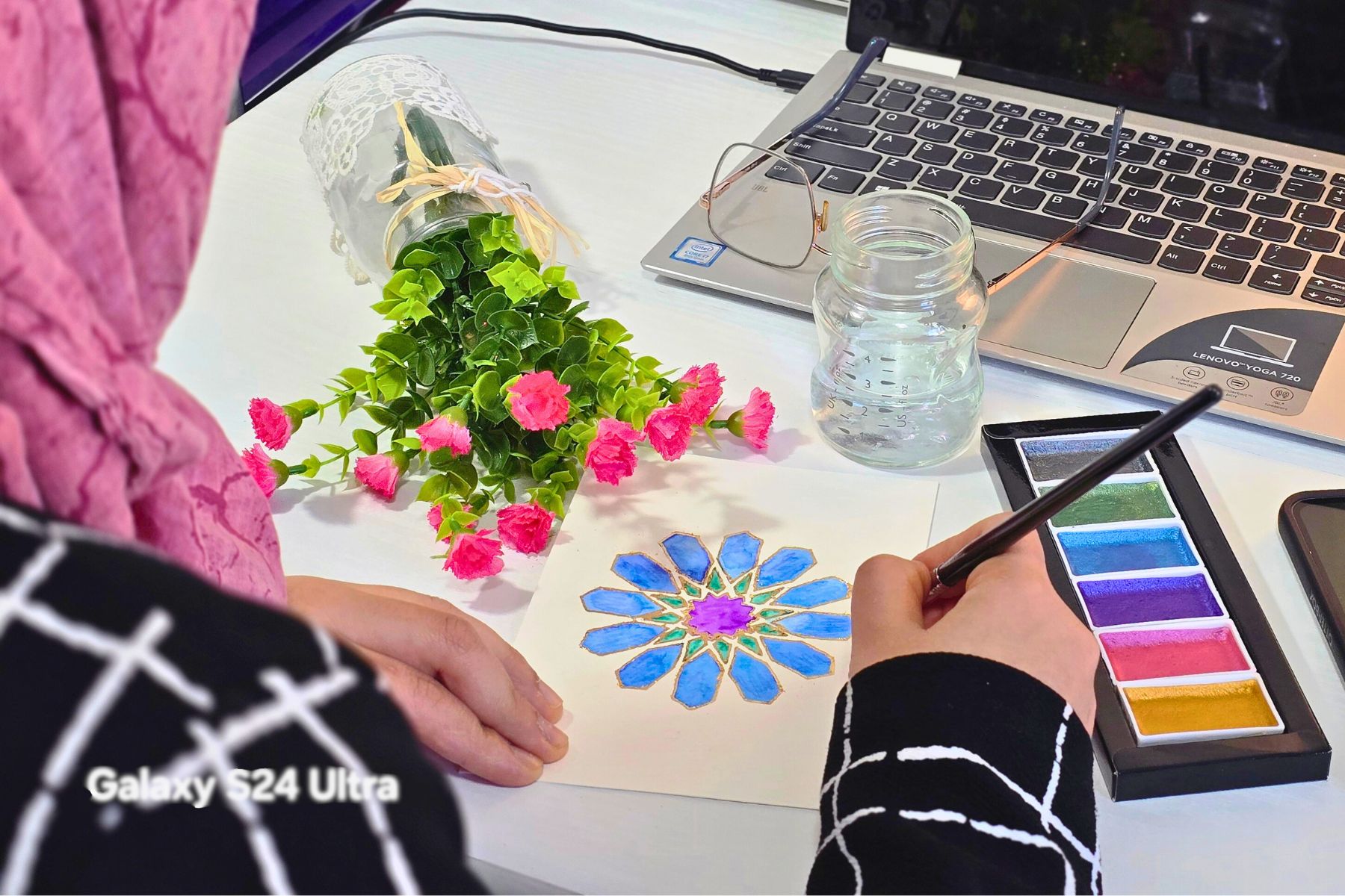 Image of an artist painting an islamic geometry in watercolor.